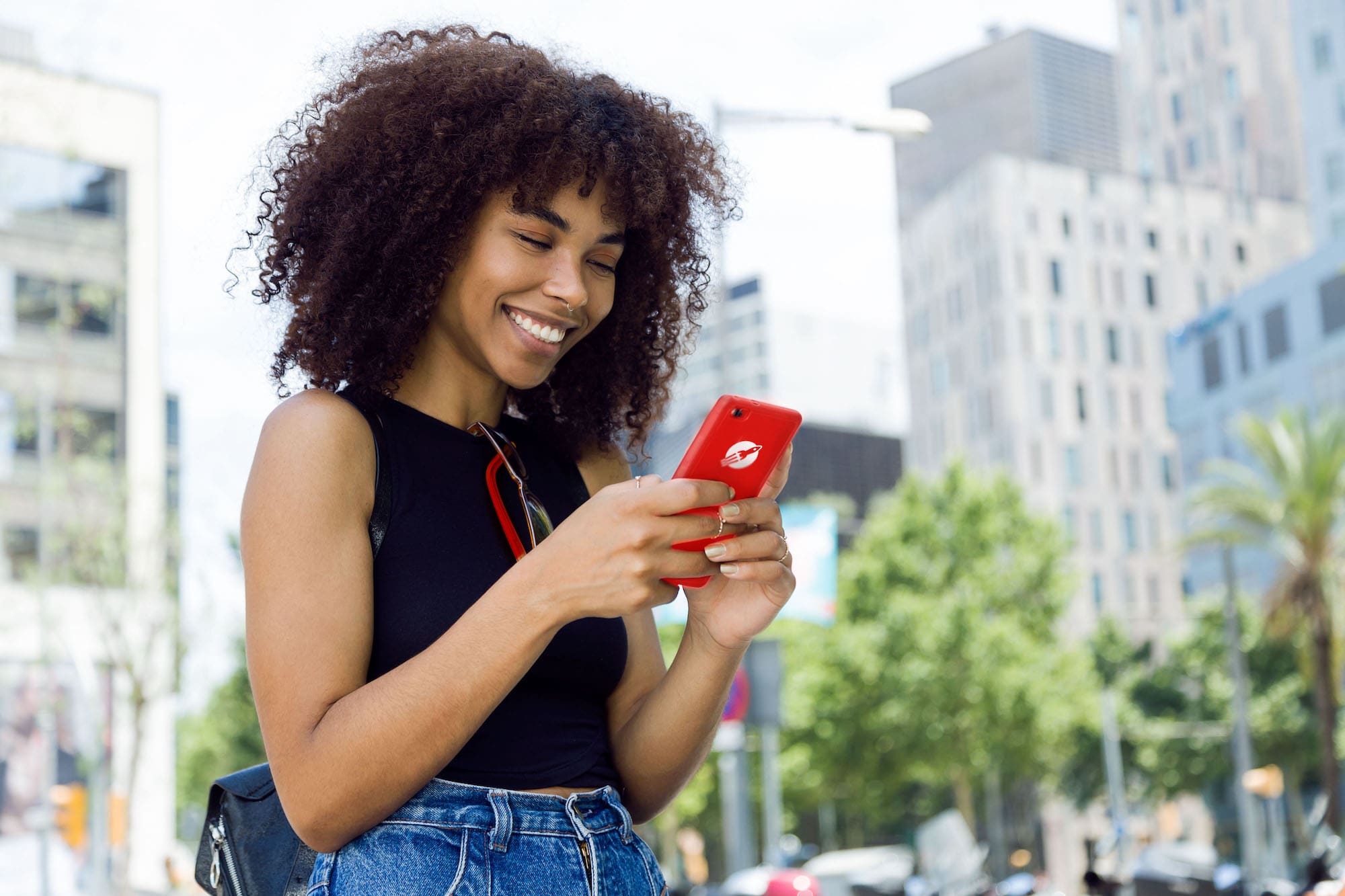 Portrait of beautiful young woman using her mobile phone in the street.